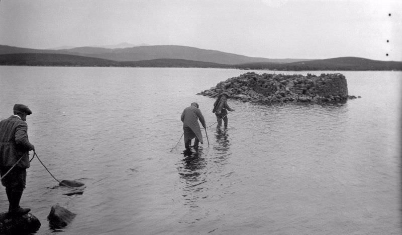 #30 View of RCAHMS surveyors wading out to a dun in 1924, Dun Nighean Righ Lochlainn, North Uist.