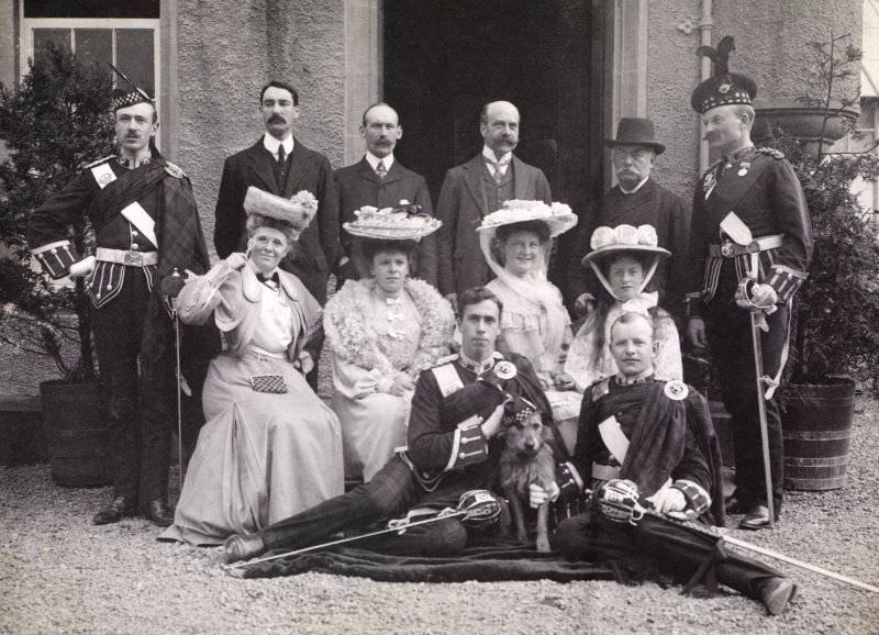 #38 Group of 12 people outside entrance, possibly at Aikenshaw, c.1904. Titled: ‘S K Turnbull, A Arrol Snr, Montagu Baird, Campbell of Cambusaskin, Franklyn Baird, A Theo Arrol, Miss Wm Arrol, Baroness V Grote, Miss G Arrol, Mr Baird’.