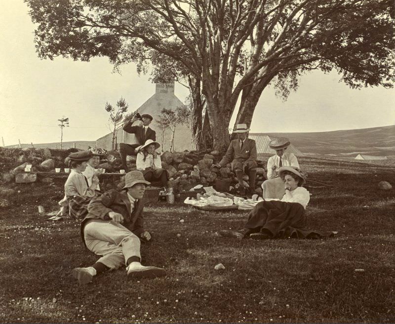 #51 Group having picnic, 1907. Headed paper on the album page is titled ‘Achernack, Grantown-on-Spey’. Photograph titled: ‘I Asher, A Henderson, T Horne, E Macpherson, B Younger, M Younger, R Bruce-Clark, H J Horne’