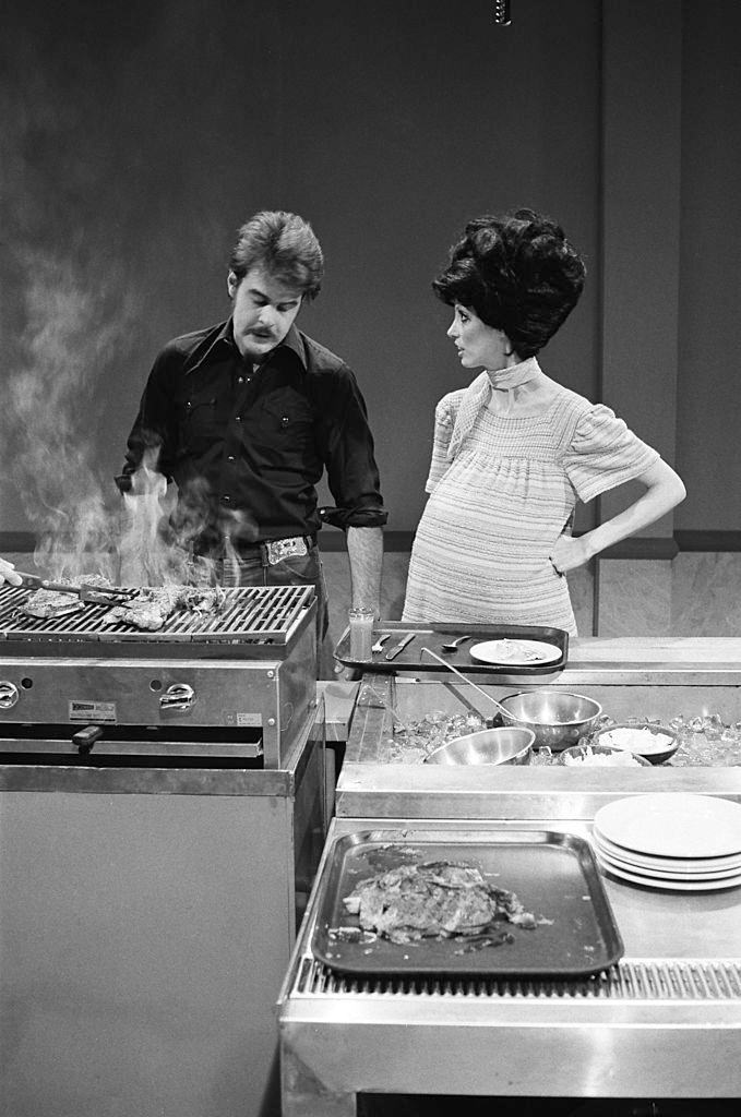 #22 Dan Aykroyd as husband, Shelley Duvall as wife during the ‘Steak House’ skit on May 14, 1977