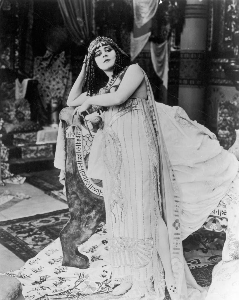 #10 Theda Bara, wearing a costume with entwined sequined snakes and a headdress, 1917.