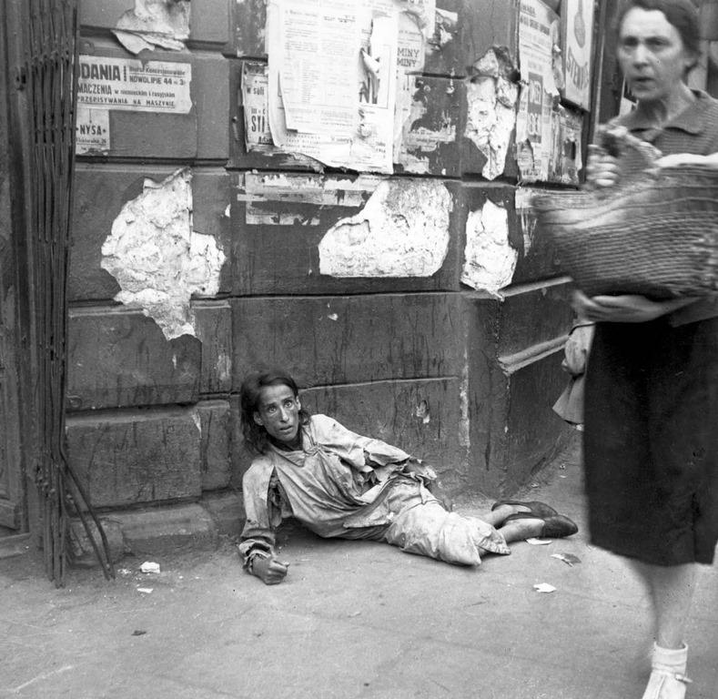 #2 A woman lying on the pavement in the Warsaw ghetto, starving to death, 1941.