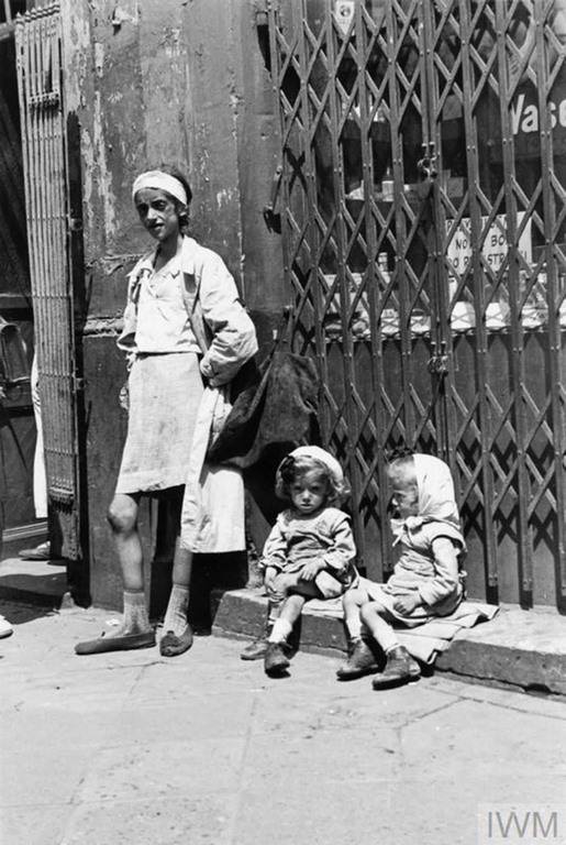 #28 An emaciated mother with her twin daughters in the ghetto.