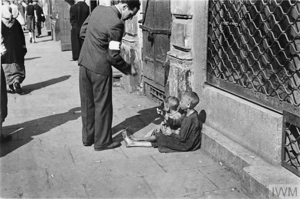 #19 A passer-by giving money to two children.