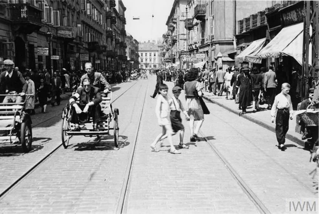 #26 Crowds of pedestrians and street rickshaws in busy Karmelicka Street in the ghetto.