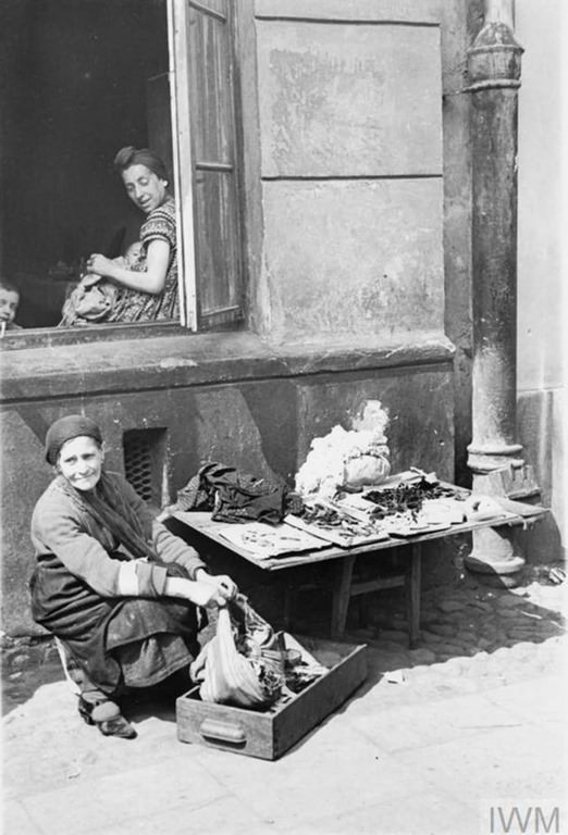 #5 An elderly Jewish woman selling her scarce possessions in the street of the ghetto.