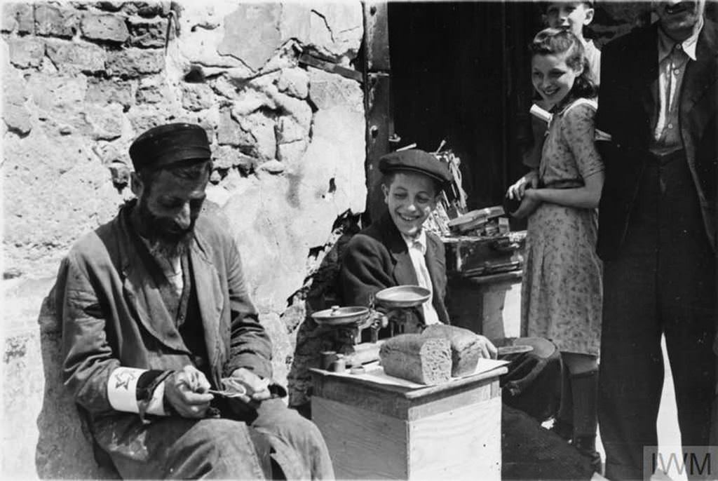 #3 A Jewish man selling his bread allowance in the street of the ghetto, summer 1941.