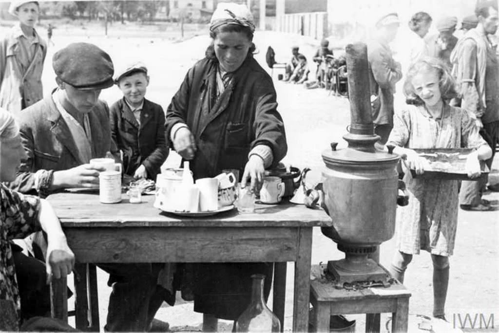 #10 A female tea seller serving hot drinks to customers in a makeshift cafe in a street market in the ghetto.