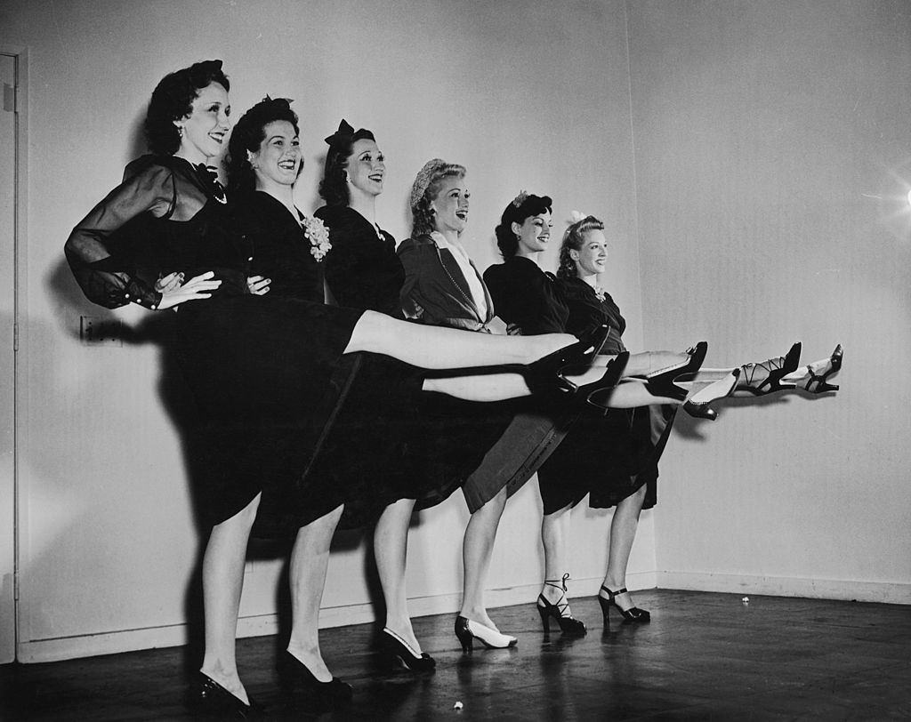 #22 Members of the Radio City Rockettes modelling Legstick, make up to replicate stockings designed to combat wartime shortages, circa 1942.