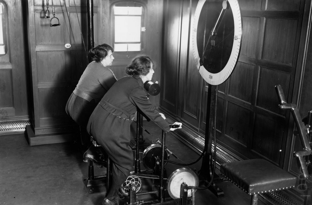 #6 Two women using the cycle machine in the gym on board the Homeric Liner, taken over from the Germans by White Star. 1922