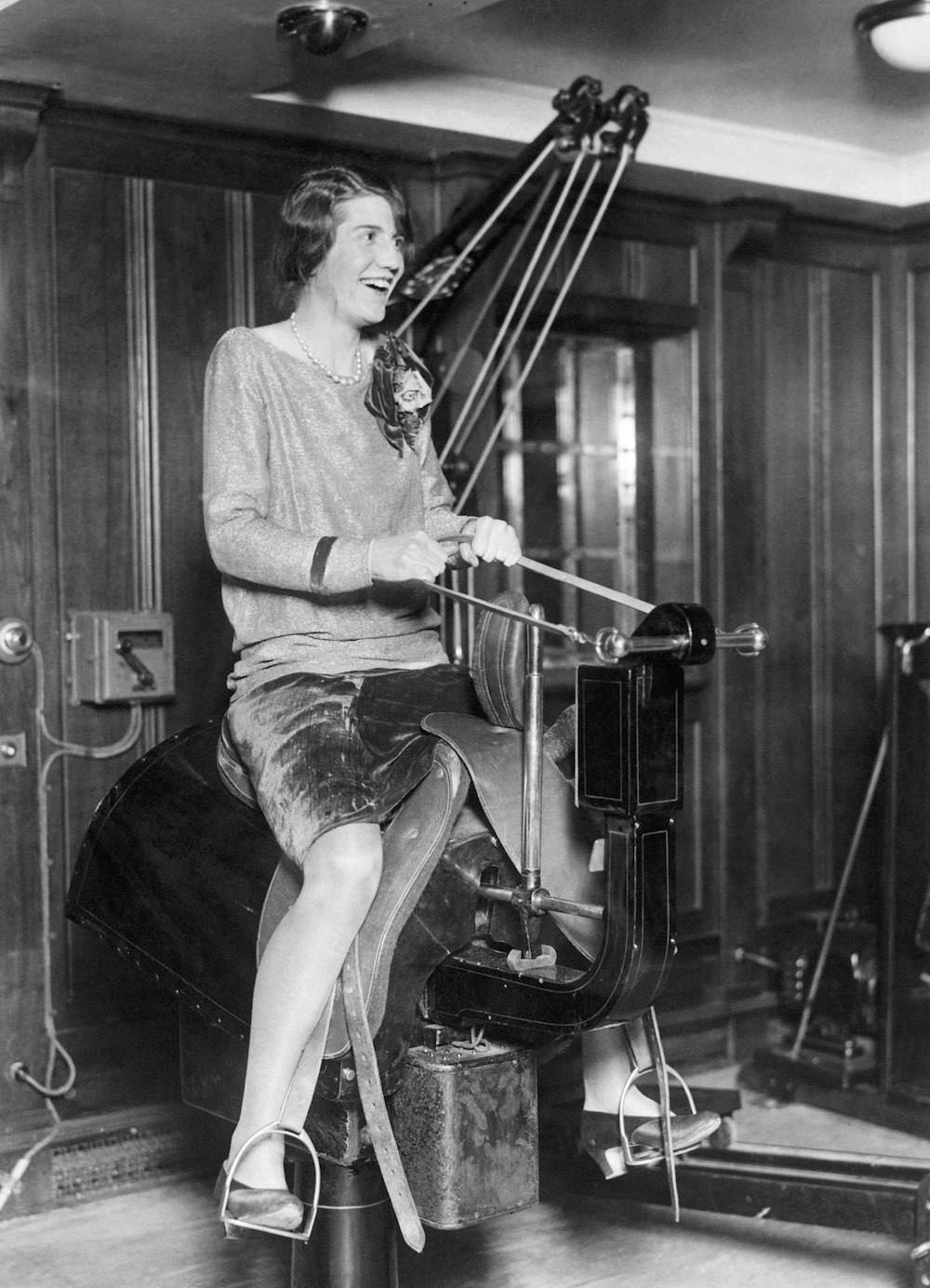 #7 A young woman passenger riding the electric horse in the gym on the liner SS Bermuda. Mid 1920s