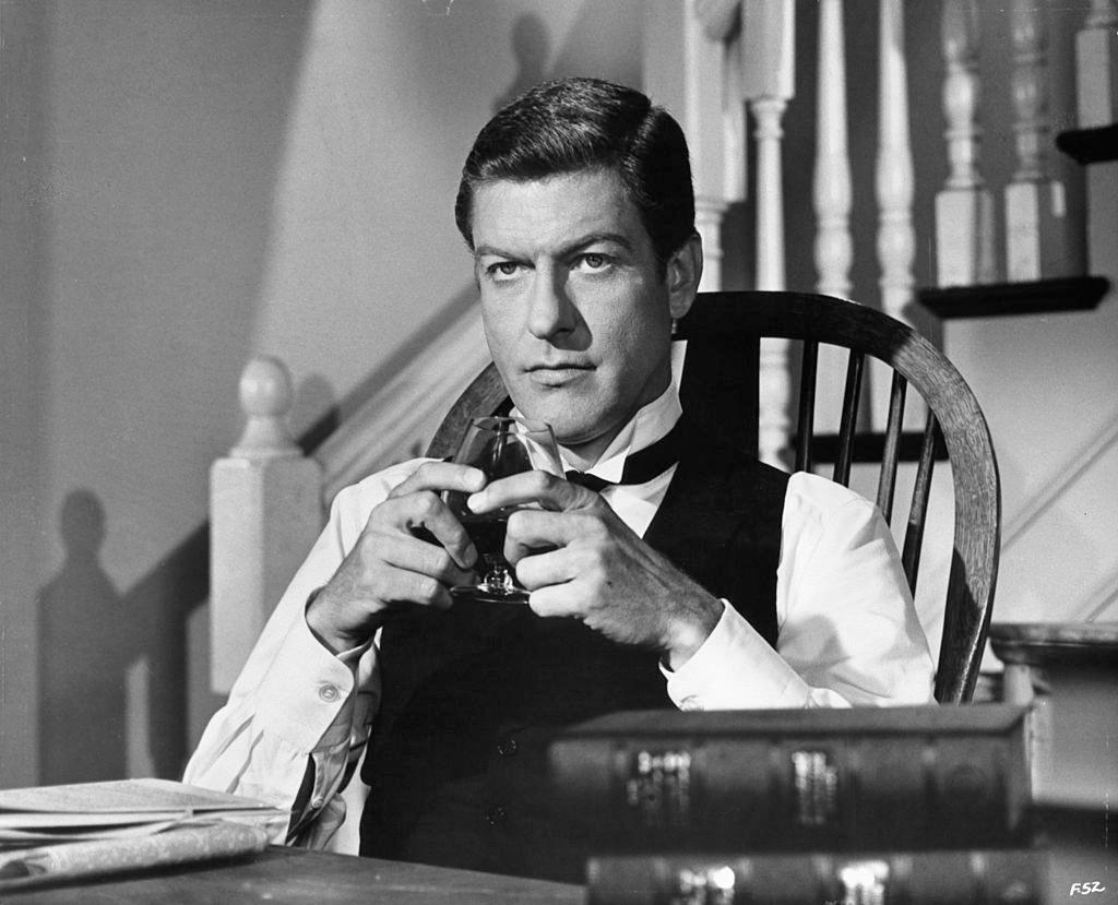 #29 Dick Van Dyke sitting in a tuxedo holding a snifter glass in a scene from the film ‘Fitzwilly’, 1967.