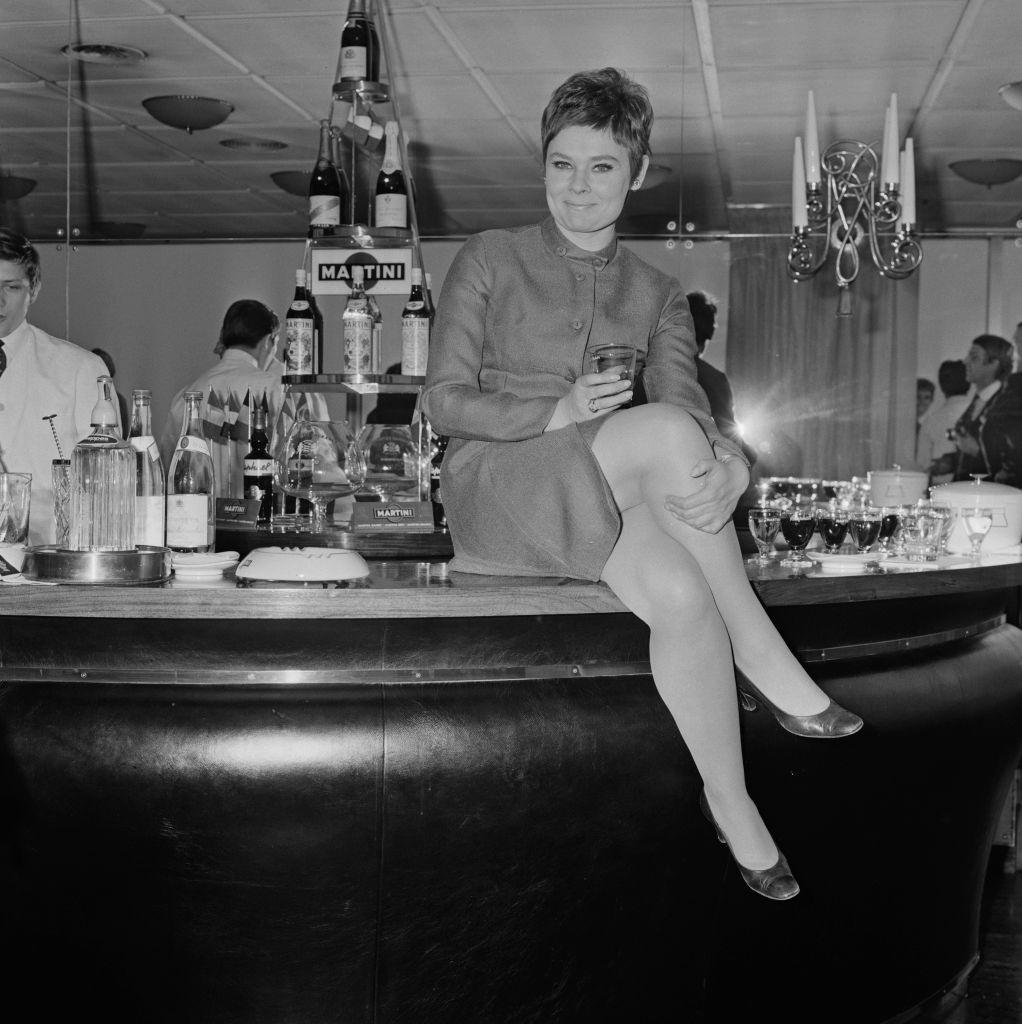 #23 Judi Dench sitting on a bar counter, UK, 9th April 1968.
