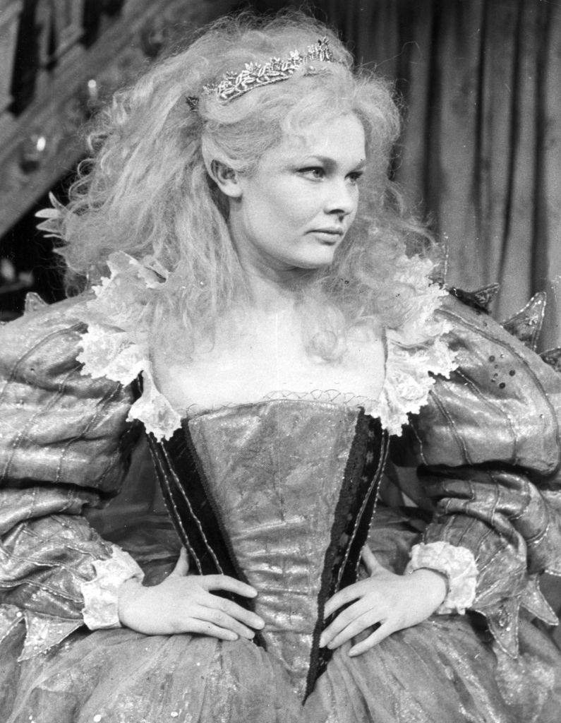 #3 Judi Dench wearing a wig and a long ruffled gown, 1962.