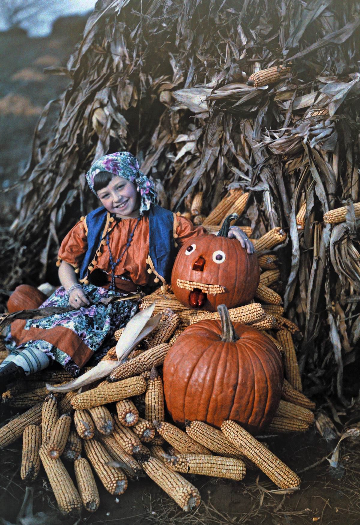 #3 A girl poses with corncobs and pumpkins during the harvest, Virginia.