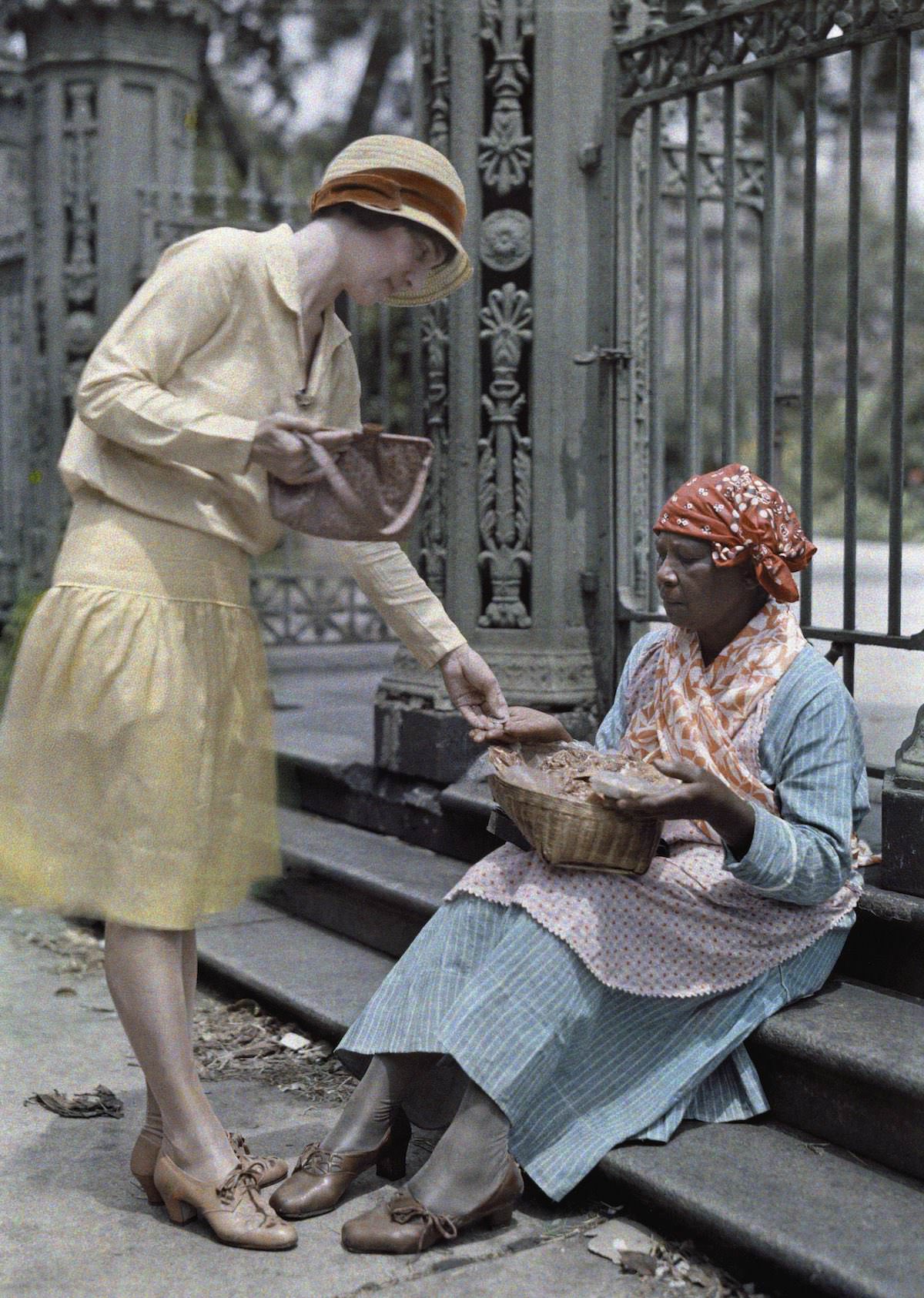 #34 A woman sitting on stone steps in the French Quarter sells pralines.