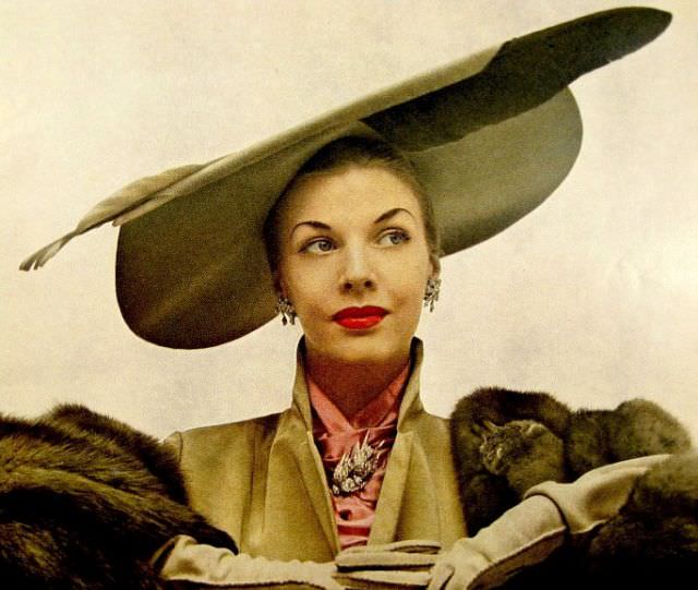 #15 Model is wearing hat with large feather by Lilly Daché, Vogue, November 1948