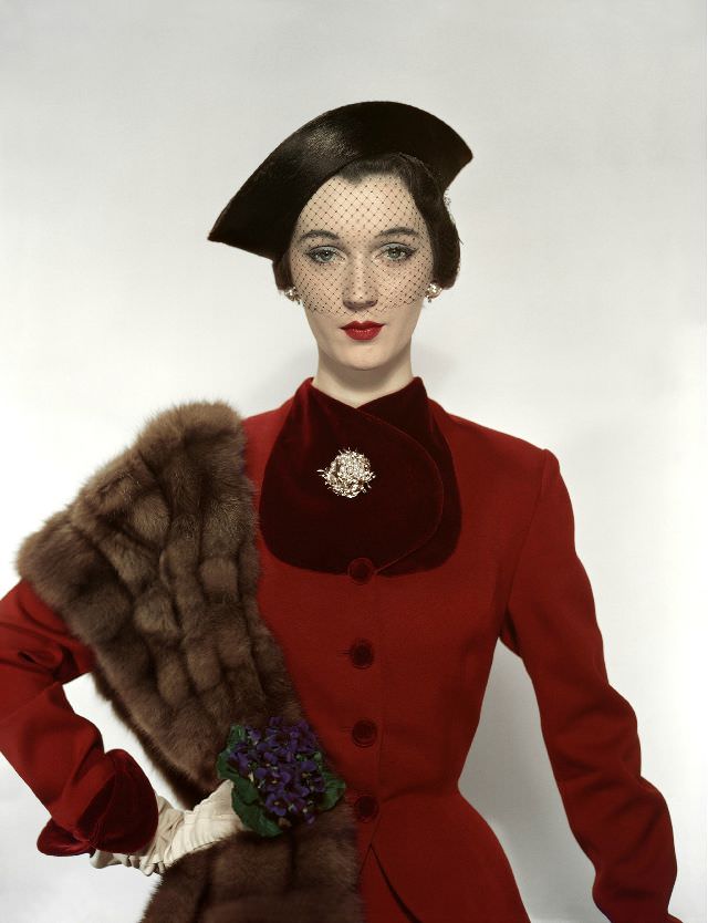 #18 Dovima in Pacific Craft Fabric woolen suit trimmed in velvet, hat, and brooch by Verdura, Vogue, August 1, 1950