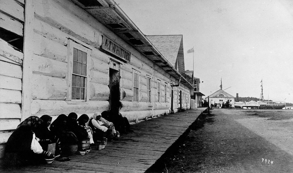 #47 Crowd huddled next to building in Sitka, Alaska, circa 1890.