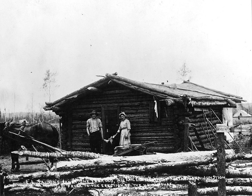 #3 Man and woman as they pose at the doorway of a log cabin, Alaska, 1860s
