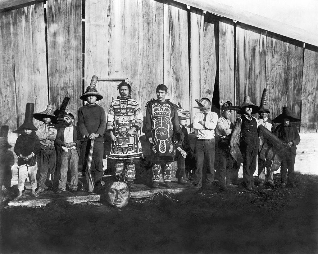 #23 Indians in old dancing costumes in front of Chief Klart-Reech’s house, Chilkat, Alaska, 1895.