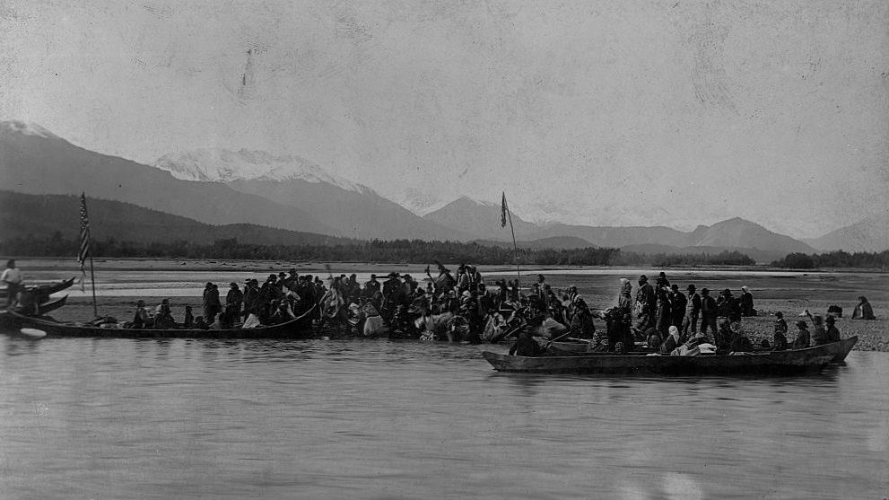 #24 Tlingits gather on bank of a gravely sandspit for a potlatch dance, prior to the actual potlatch feast, along the Chilkat River. Alaska 1895.