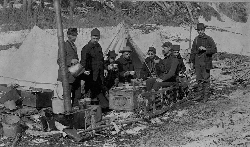 #38 A group of prospectors eat lunch on a crate, on the Yukon Trail. Alaska, 1897.