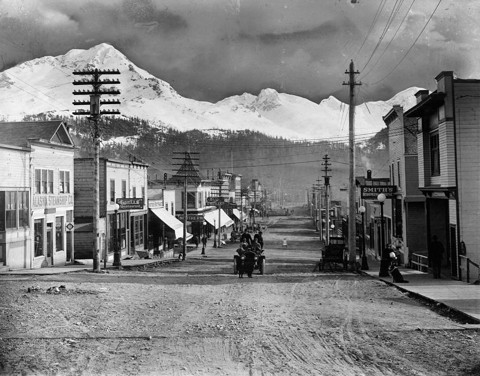 #5 A main street in Cordova, Alaska, with utility poles, boardwalks, and light traffic, 1868.