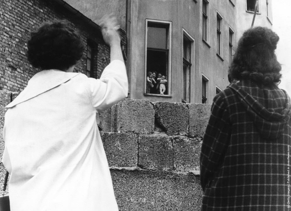 #101 Two mothers can only wave to their children and grandchildren in the Soviet sector of Berlin from across the Berlin wall, 1961.