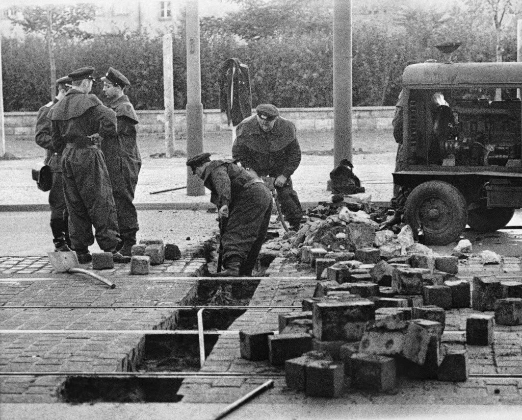 #20 Members of the East German military remove paving blocks on Friedrich Strasse in East Berlin August 13, 1961.