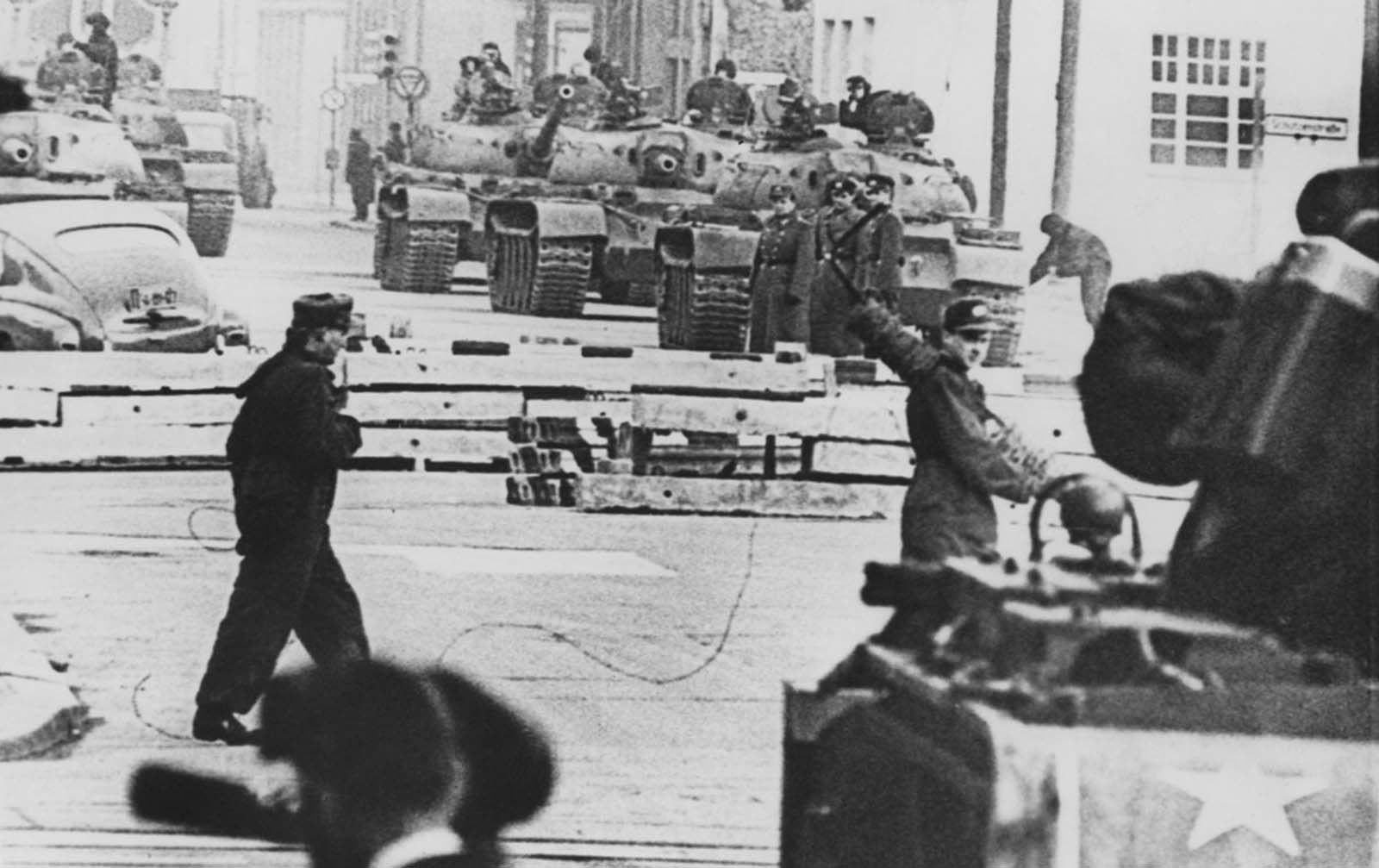 #52 Russian (background) and American (foreground) tanks face each other at the Friedrichstrasse checkpoint in Berlin during the construction of the Berlin Wall on October 28, 1961.