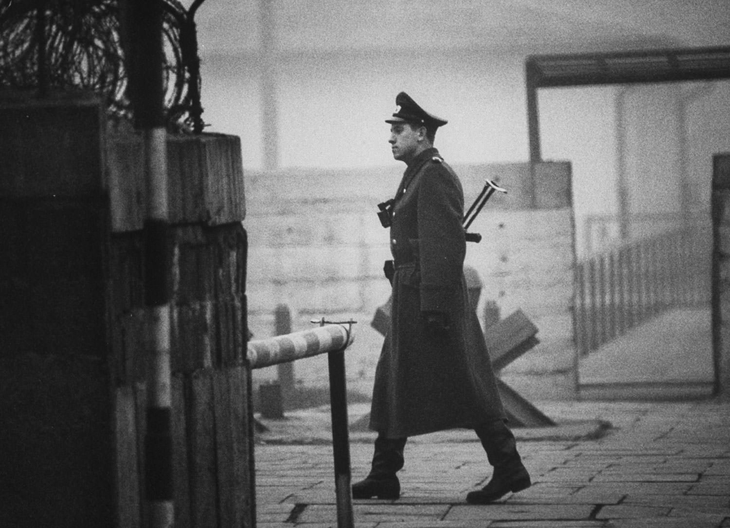 An East German policeman, known as a Volkspolizei or “people’s police” — Vopo for short — walks at Checkpoint Charlie between East and West Berlin in October 1962.