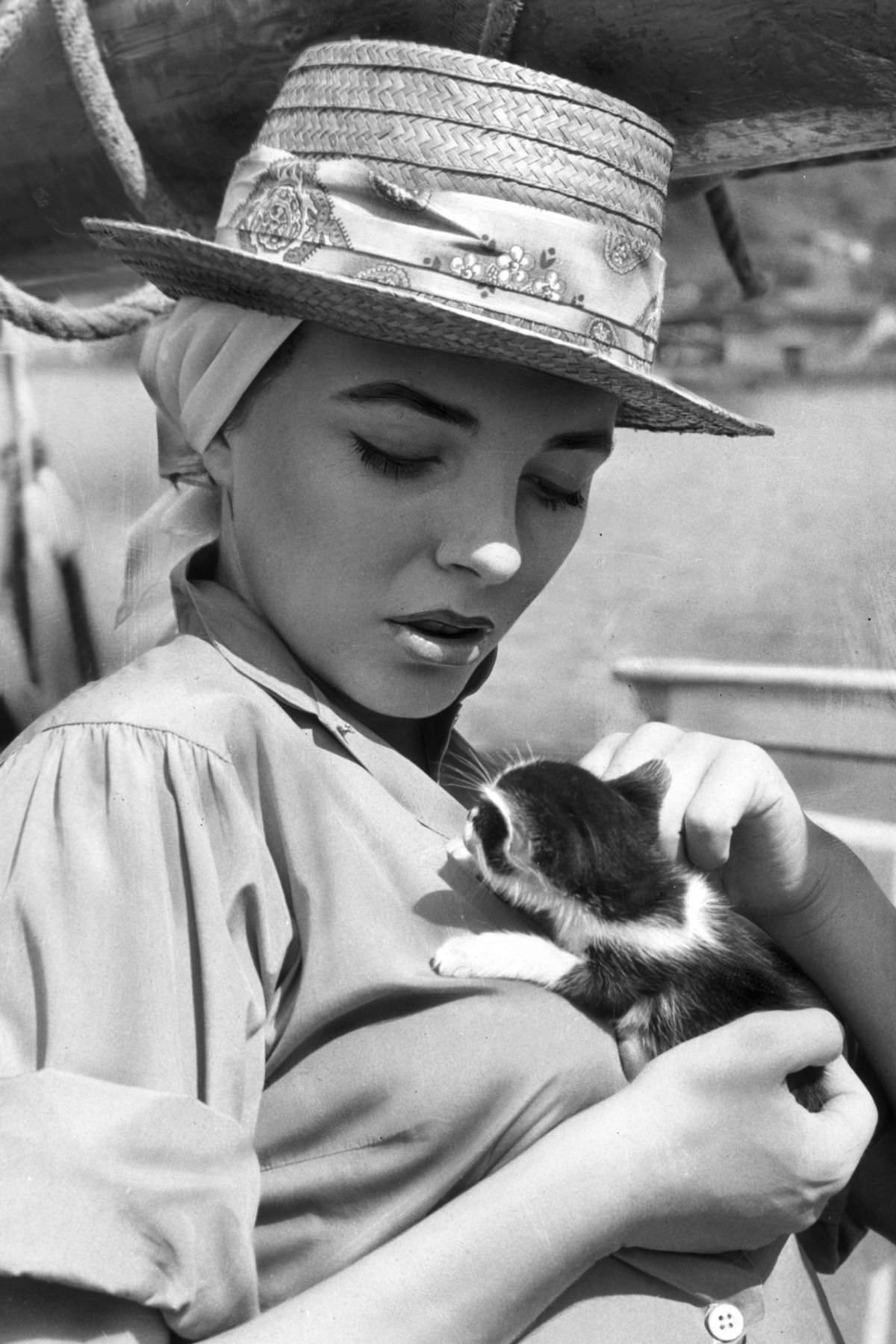 #14 British-born actress Joan Collins lounged on a boat that came with its own kitten, 1957.
