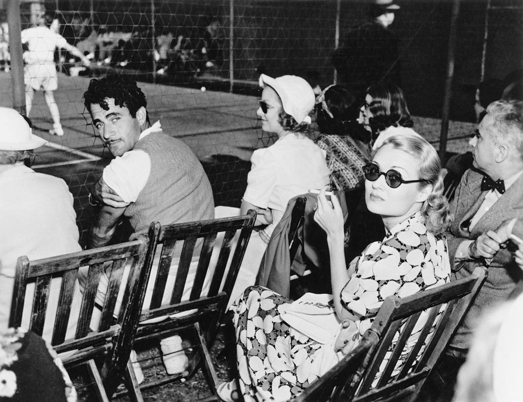 #30 Constance Bennett sitting with Mexican leading man Gilbert Roland at Beverly Hills Tennis club, 1932.