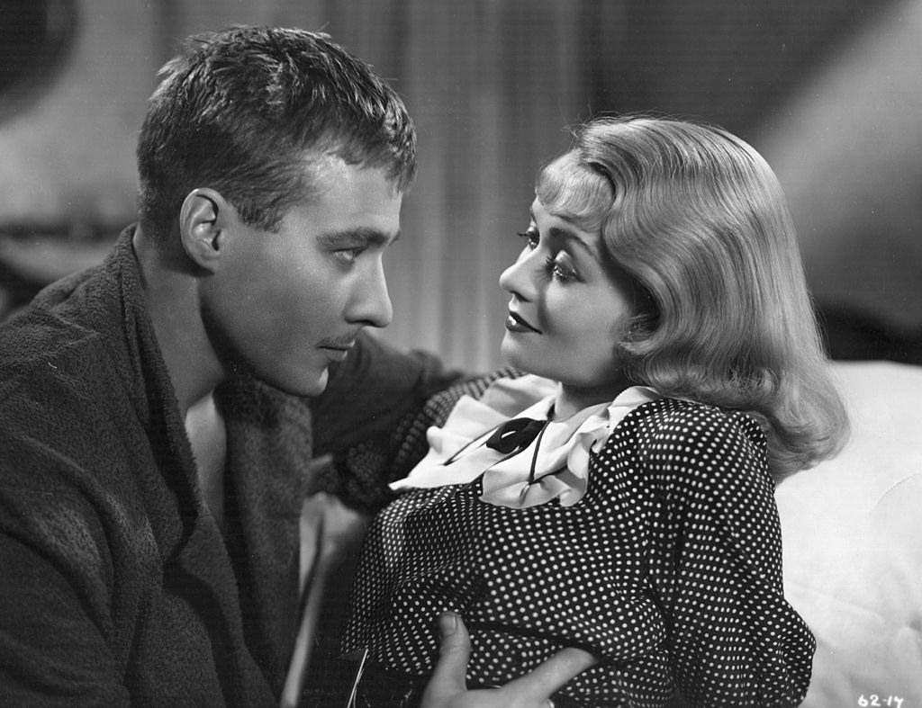 #46 Constance Bennett with Douglass Montgomery in the film ‘Everything Is Thunder’, 1936.
