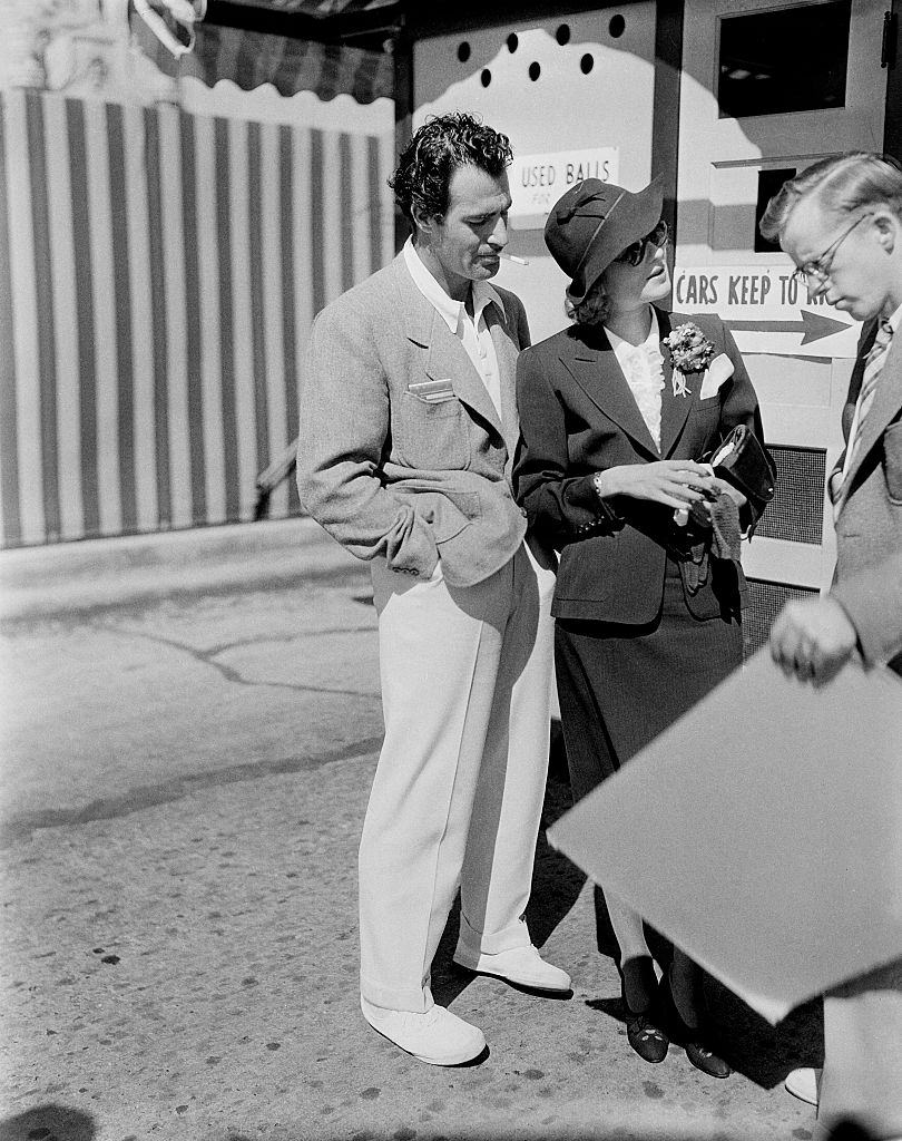 #3 Gilbert Roland and actress Constance Bennett talk to a fan in Los Angeles, 1940.