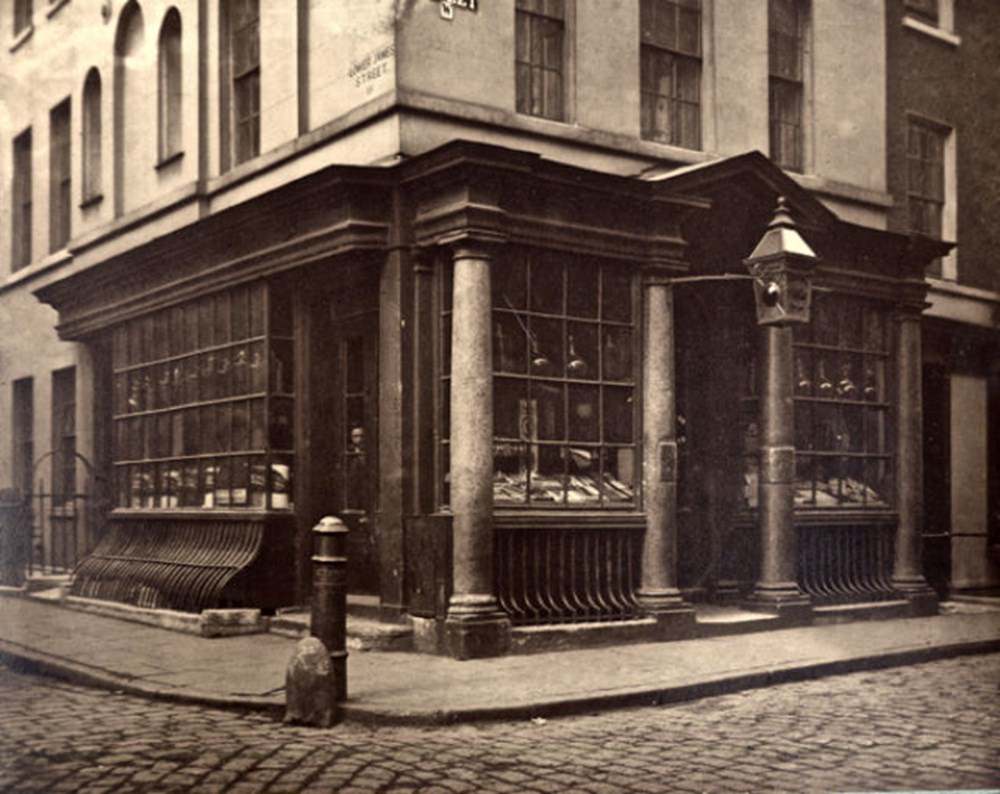 #13 A man peers from the window of a chemists’ at the corner of Lower James St and Brewer St.