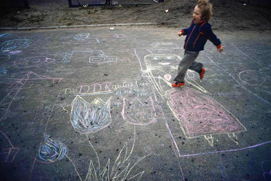 #11 A boy playing. Paintings on asphalt in a school yard. East Berlin, 1974.