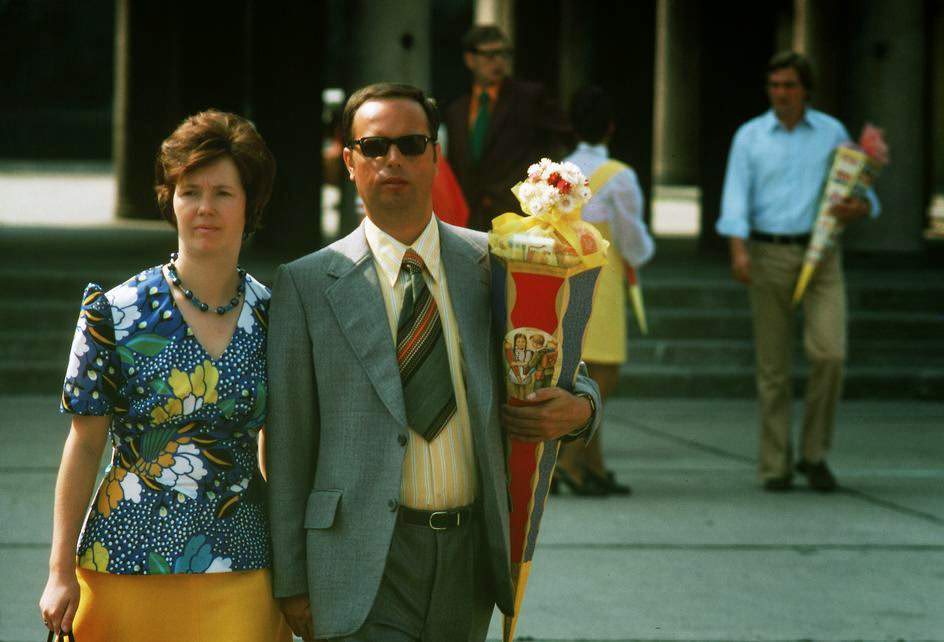 #51 Proud parents carry a traditional candy bag on the first day of school for their in Berlin-Friedrichshain. East Berlin, 1974