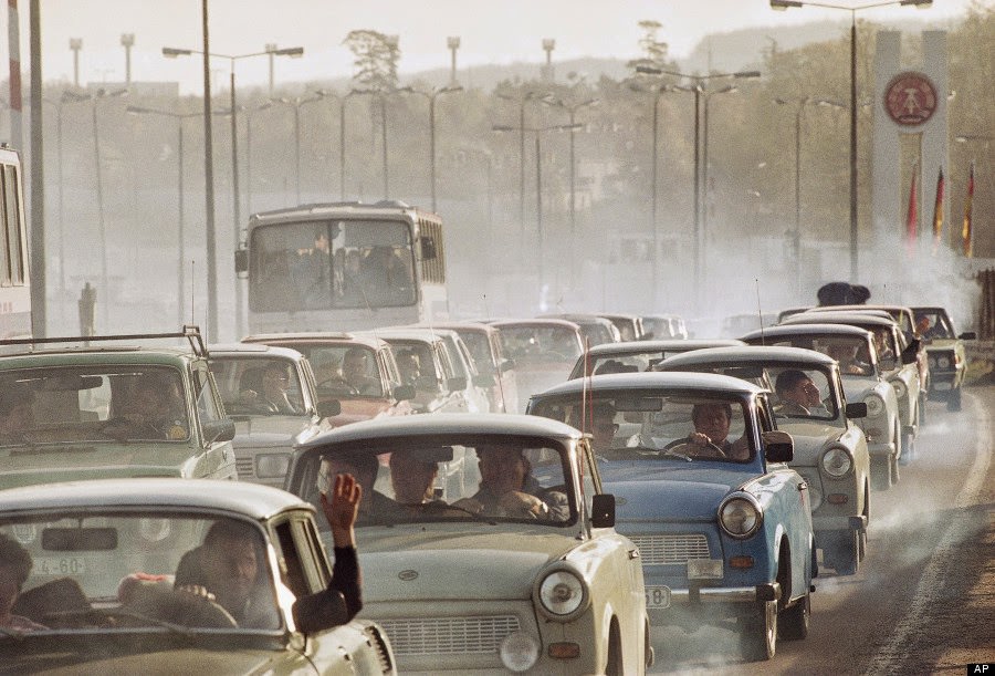#6 In a giant cloud of exhaust fumes of two-stroke engines, hundreds of East German cars wait bumper to bumper in front of the West German checkpoint Helmstedt to enter the west, Nov. 11, 1989.