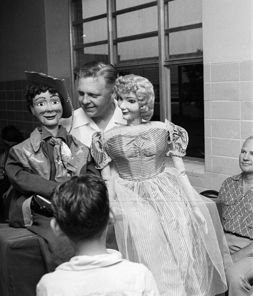 #19 Man holding puppets during a blood drive, Houston, Texas, 1953