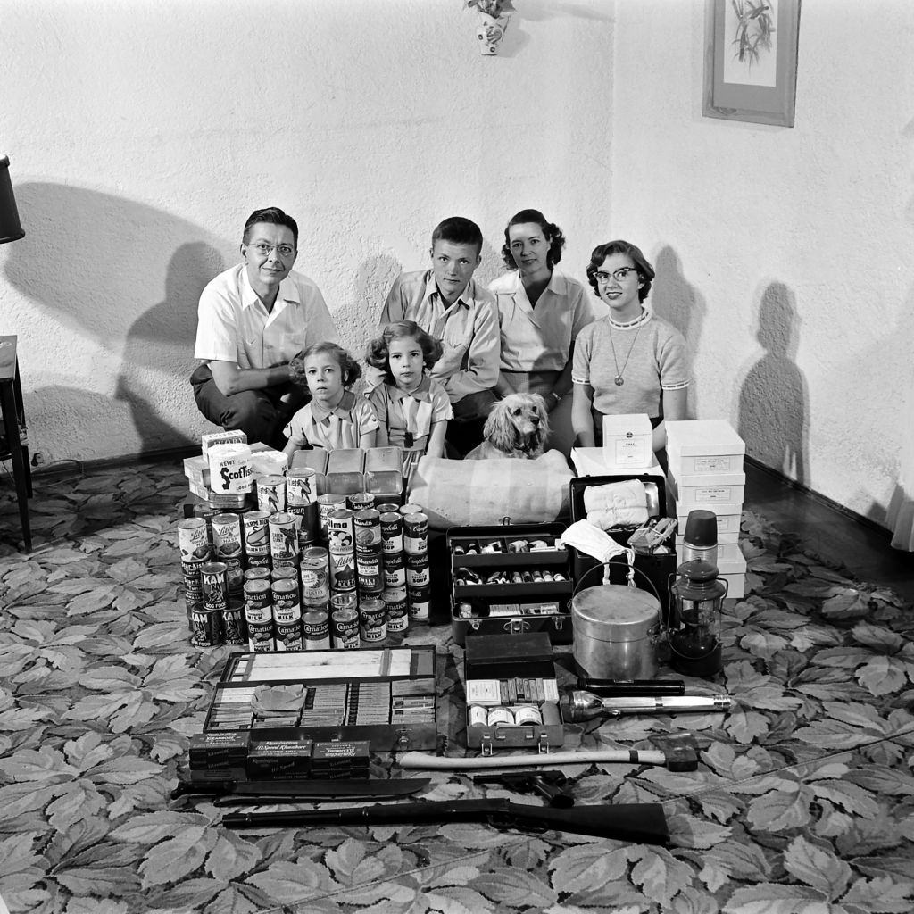 #8 Family preparing for atomic war posing with food and first aid supplies for their makeshift bomb shelter in Houston, Texas, March 1954.