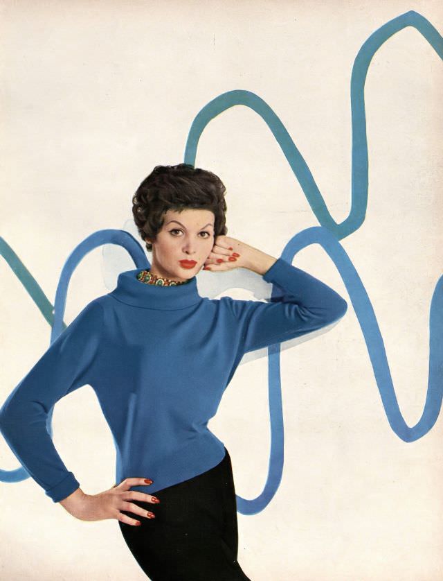 #10 Isabella Albonico in deep blue cashmere sweater with big wide turtleneck collar by Braemar, worn with faux emerqalds by Hattie Carnegie. Harper’s Bazaar, August 1957