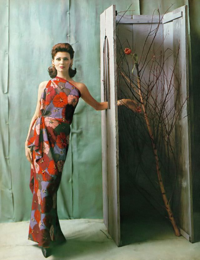 #32 Isabella Albonico in asymmetric evening gown of colorful floral print in Bianchini silk by Galanos, Miriam Haskell earrings. Harper’s Bazaar, April 1960
