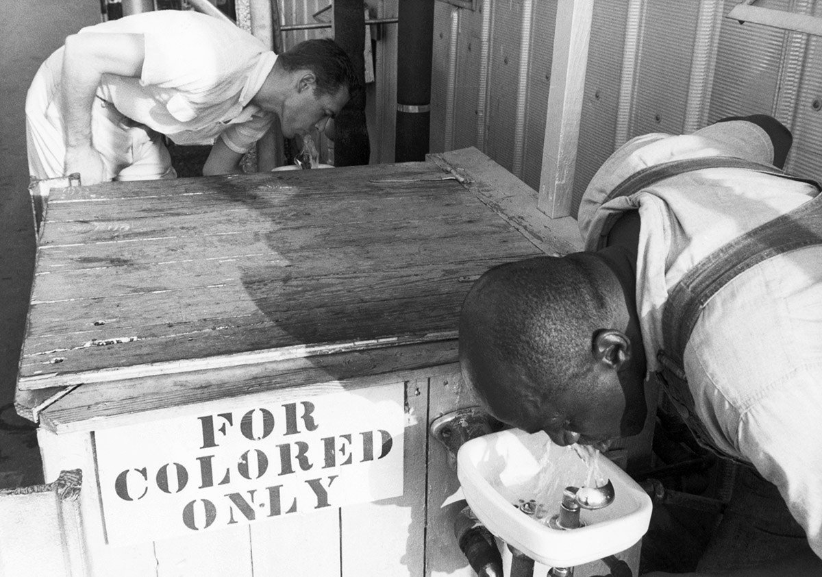 #22 Men drink from segregated water fountains.