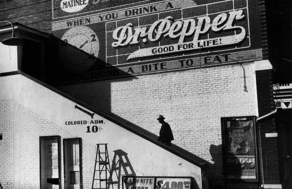 #7 An African-American climbing up the stairs to the segregated section of a cinema in Belzoni, Mississippi, 1939.