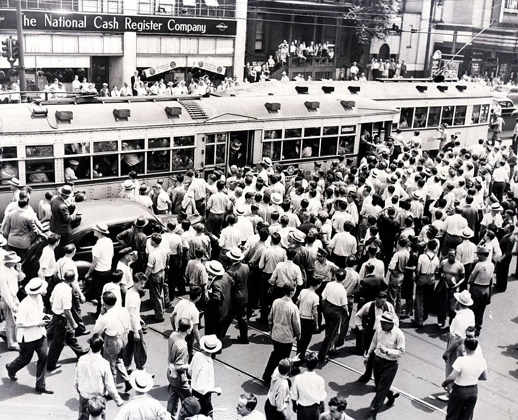 #52 An angry white mob surrounds a street car with African American passengers stopped due to the race riots in Detroit.