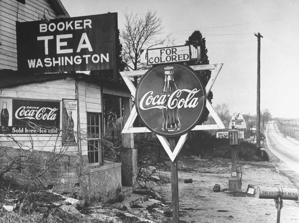 #59 For Colored, sign atop round Coca-Cola sign tacked to a wooden Star of David in Washington, 1938.