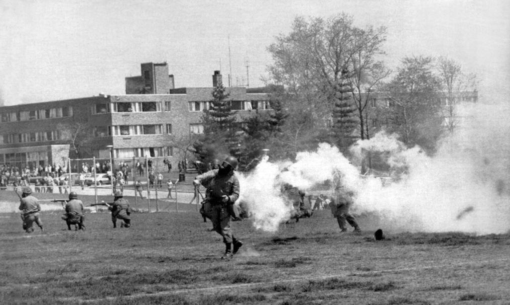 #14 National Guard troops throw tear gas into the rioters at Kent State protesting the American invasion of Cambodia.