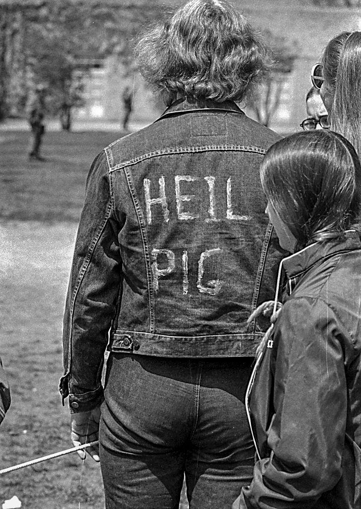 An unidentified Kent State University student in a jean jacket on which is written ‘Heil Pig,’ a reference to the on-campus presence of the Ohio National Guard